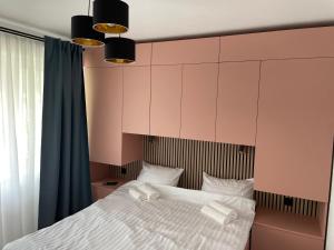 a bedroom with a large bed with white sheets at Apartament Tei in Gura Humorului