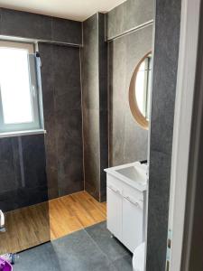 a bathroom with a white sink and a mirror at Apartament Tei in Gura Humorului +8 photos