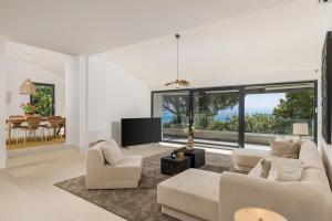 a living room with two couches and a tv at Villa Carla house with hot tub and beautiful garden in Ičići
