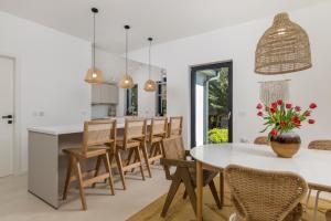 a kitchen and dining room with a white table and chairs at Villa Carla house with hot tub and beautiful garden in Ičići