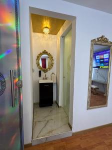 a bathroom with a mirror and a sink at HOTEL PERSEO - Suites elegantes por noche o 5 horas in Mexico City