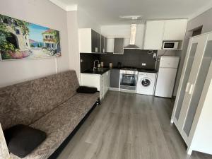 a living room with a couch and a kitchen at Pi Sunyer Studio. in Roses