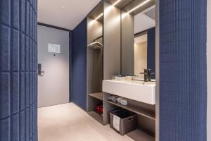 un bagno con lavandino e specchio di Atour Light Hotel Beijing International Exhibition Center Liufang Subway Station a Pechino