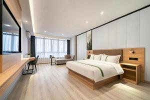 ein Schlafzimmer mit einem großen Bett und einem Schreibtisch in der Unterkunft GreenTree Inn Jiaxing ZhongHuan South Road Zhonggang City Express Hotel in Jiaxing + 248 Fotos