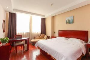une chambre avec un lit, un bureau et une chaise dans l'établissement GreenTree Inn HuaiAn Xiangyu Avenue International Mall Business Hotel, à Hexia 172 autres photos