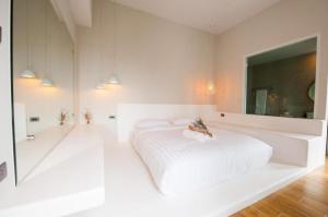 チェンマイにあるJowa Hotelの白いベッドルーム(ベッド1台、大きな鏡付)