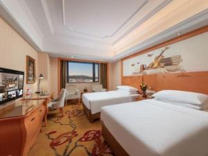 a hotel room with two beds and a television at Vienna International Hotel Guangzhou Jichang Road Huangshi in Guangzhou +205 photos