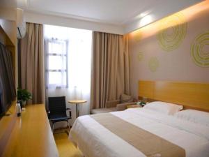 a hotel room with a large bed and a chair at GreenTree Inn Xianning Tongshan Yangdu Avenue in Xianning