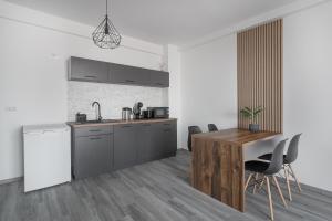 a kitchen with a counter and a table and chairs at Golden Hour Apartment in Baile Felix +10 photos