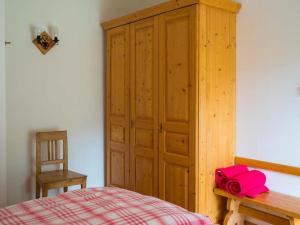 a bedroom with a bed and a wooden cabinet at Hütterhof in Grundlsee