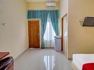 a room with a door and a window and a room with at OYO 90945 Arizon Kost in Jambi +72 photos