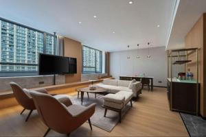 a living room with a couch and a tv at Hangzhou Qiantang Shama Hotel in Hangzhou