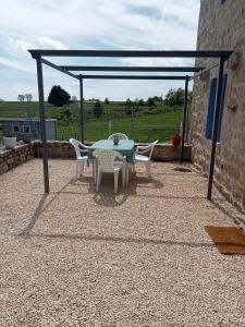 a patio with a table and chairs under a canopy at Gîte La Béate des Arnauds in Tiranges +3 photos