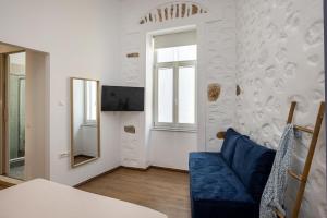 a living room with a blue couch and a window at Irene Studios in Ermoupoli