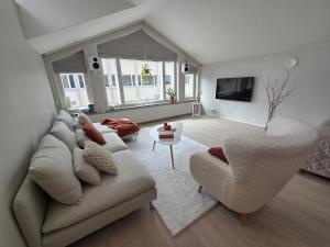 a living room with a couch and two chairs at Kotoisa kattohuoneisto in Laitila