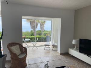 d'un salon avec des chaises et une télévision ainsi que d'une terrasse. dans l'établissement Villa Ancône, à Calcatoggio