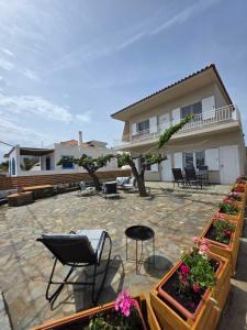a house with a patio with some plants and chairs at Sea Lilly in Agia Anna +62 photos