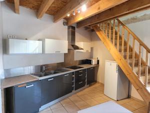 a kitchen with gray cabinets and a wooden staircase at Appartement a louer à Cruas in Cruas