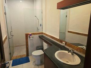 łazienka z umywalką, toaletą i prysznicem w obiekcie Keke Homestay Sanur w mieście Sanur