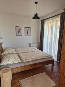a bed in a bedroom with a large window at High Tatras Apartment J303 in Veľká Lomnica