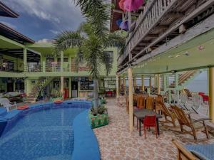 a resort with a swimming pool and tables and chairs at Sascha's Resort Oslob in Oslob