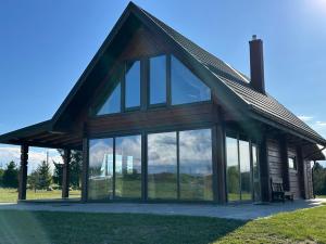 a house with large glass windows in a field at 12 Bijūnų in Joniškis