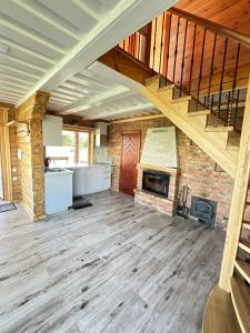 an open living room with a staircase and a fireplace at 12 Bijūnų in Joniškis