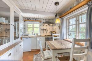 a kitchen with a wooden table and white cabinets at Ferienhaus Seeraeuberhaeuschen ID 442 in Tating +11 photos