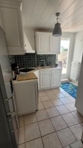 eine Küche mit weißen Schränken und einem Fliesenboden in der Unterkunft Appartement 4 chambres - Grande Terrasse -Cergy Centre in Cergy