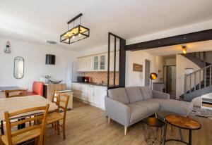 a living room and kitchen with a couch and a table at Les lauriers roses in Rampieux