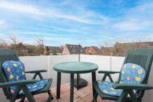 a patio with two chairs and a table on a balcony at Rechte Haushaelfte ID 905 in Sankt Peter-Ording