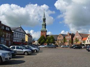 a parking lot with cars parked in front of a clock tower at Ferienhaus Ruh di ut ID 412 in Tönning