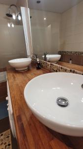 ein Badezimmer mit einem weißen Waschbecken und einem Spiegel in der Unterkunft Appartement 4 chambres - Grande Terrasse -Cergy Centre in Cergy