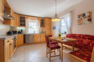 a kitchen and living room with a table and a couch at Ferienhaus Ruh di ut ID 412 in Tönning +16 photos