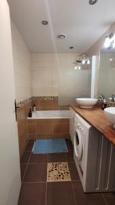 ein Badezimmer mit einer Badewanne, einem Waschbecken und einer Waschmaschine in der Unterkunft Appartement 4 chambres - Grande Terrasse -Cergy Centre in Cergy