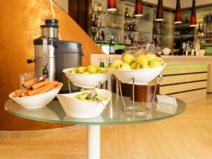 a glass table with bowls of fruit and vegetables on it at Hotel Cristallo in Giulianova