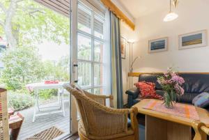 una sala de estar con un sofá y una mesa en Hausteil 8 Greetje ID 261, en Ording 16 fotos más
