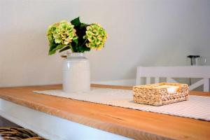 a vase with flowers and a box on a table at Wohnung 3 ID 181 in Sankt Peter-Ording