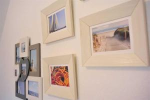 a bunch of pictures hanging on a wall at Wohnung 3 ID 181 in Sankt Peter-Ording