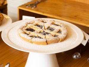 a blueberry pie on a white plate on a table at Hotel Cristallo in Giulianova