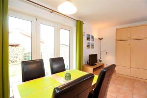 OlsdorfにあるWohnung 2 ID 153のテーブルと椅子とテレビのあるダイニングルーム