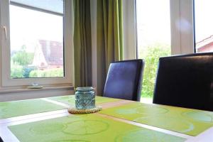 OlsdorfにあるWohnung 2 ID 153の椅子とガラス瓶が置かれたテーブル +9枚の写真