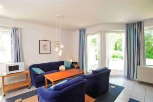a living room with a blue couch and a table at Wohnung 3A ID 057 in Sankt Peter-Ording