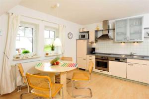 a kitchen with a table and chairs in a room at Wohnung 5 Duenengras ID 115 in Sankt Peter-Ording