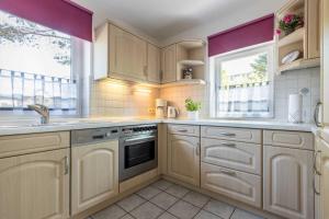 Una cocina con gabinetes blancos y una ventana. en Wohnung 4 ID 036, en Olsdorf