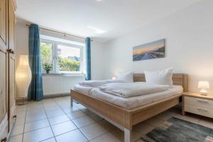Un dormitorio con una cama grande y una ventana. en Wohnung 4 ID 036, en Olsdorf