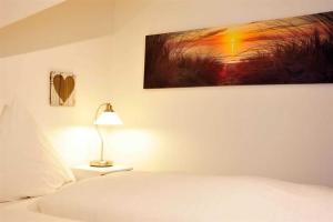 a bedroom with a bed and a lamp and a painting at Wohnung 5 ID 103 in Böhl