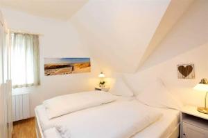 a white bedroom with a bed and a window at Wohnung 5 ID 103 in Böhl