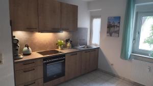 a kitchen with wooden cabinets and a sink and a window at Little Castle in Bad Kreuznach