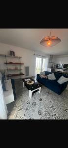 a living room with a couch and a table at La tour carree, t2 avec parking in Cité de Port-Neuf